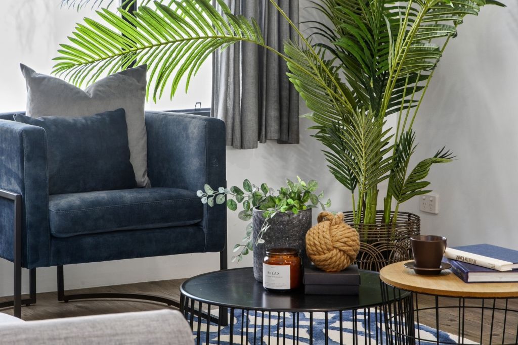 A living room with a blue chair and a black coffee table.