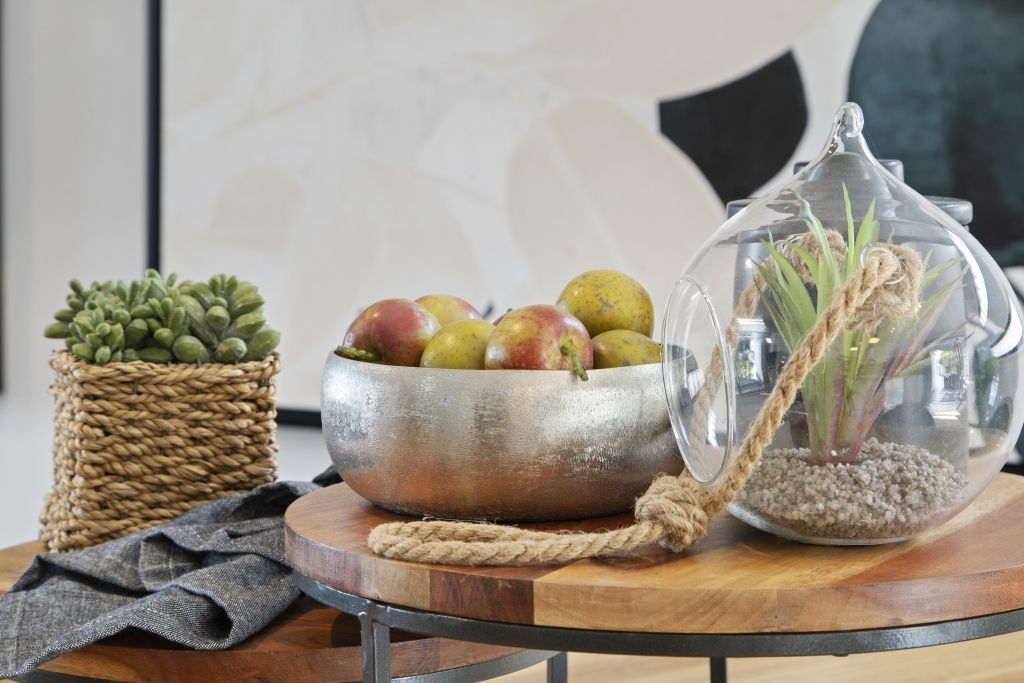 A bowl of fruit is sitting on top of a wooden table.