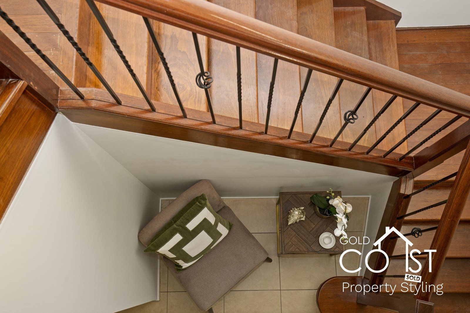 An aerial view of a wooden staircase with a chair and a table