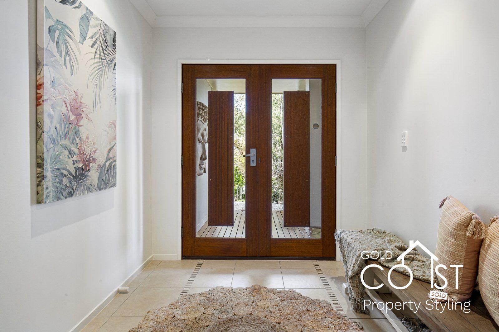 A hallway with a wooden door and a painting on the wall.