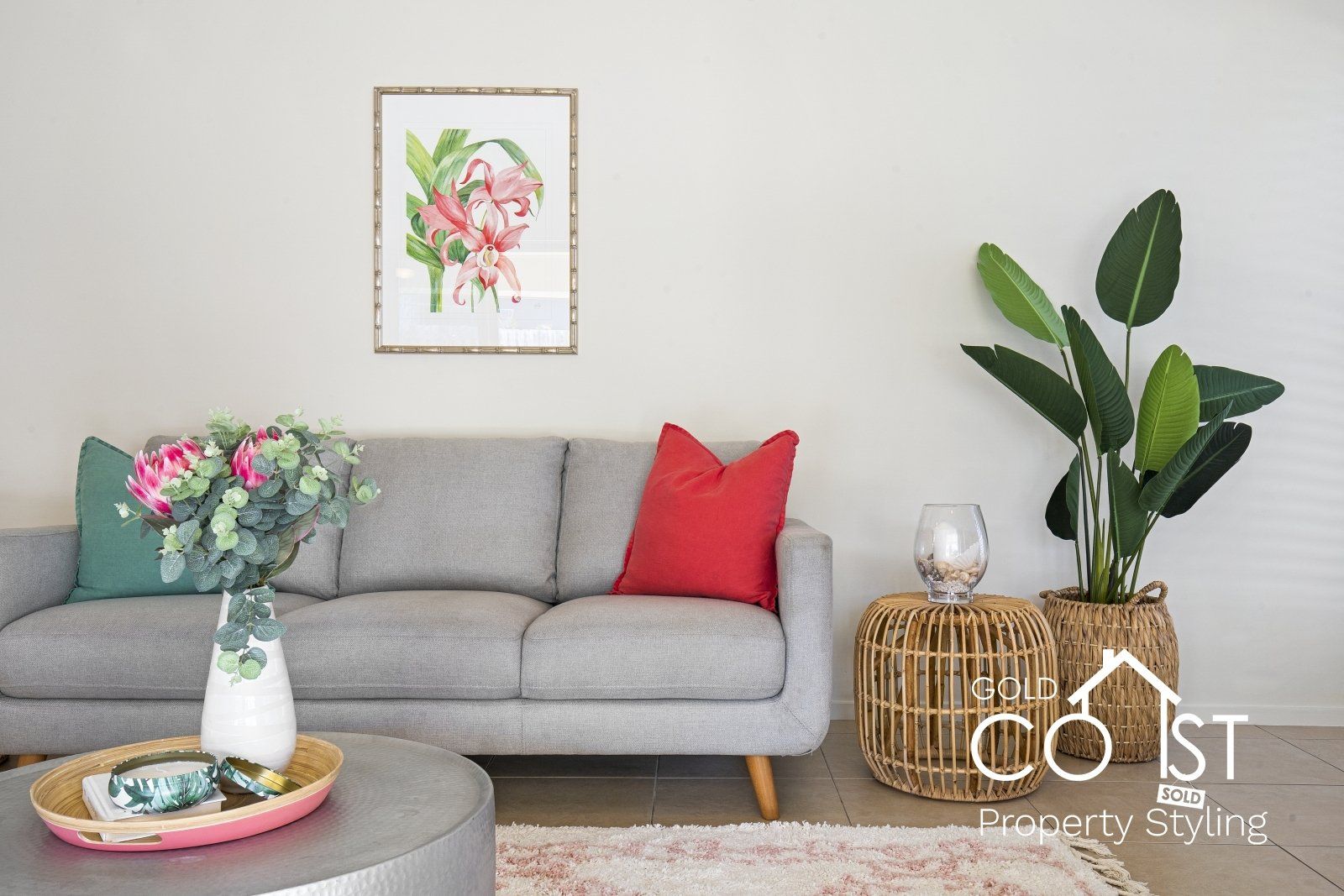 A living room with a couch , coffee table , and plant.