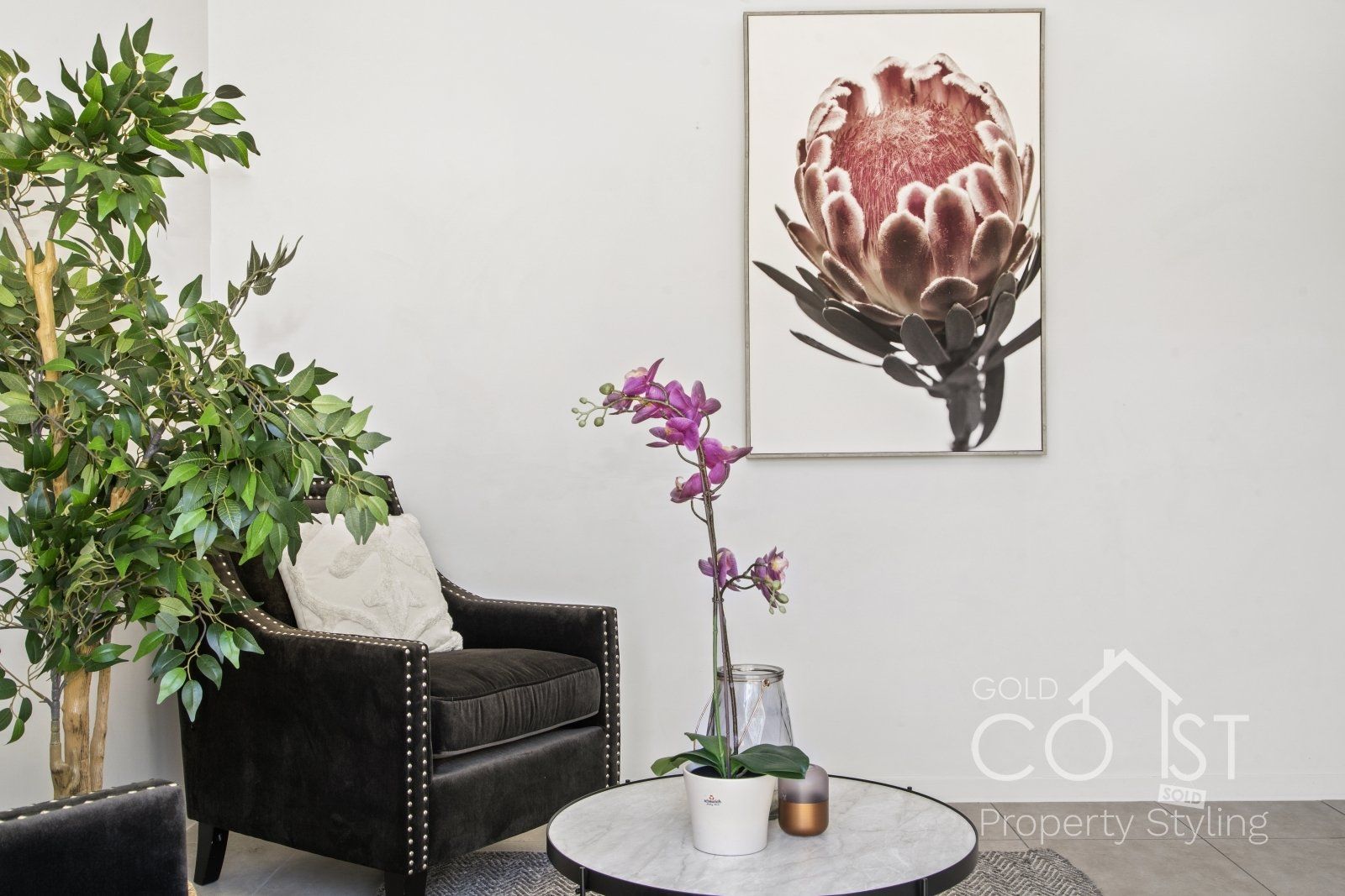 A living room with a chair a table and a painting on the wall