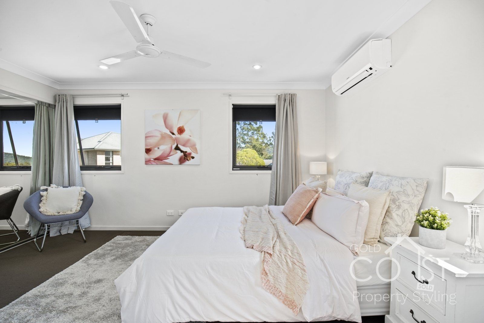 A bedroom with a large bed and a ceiling fan