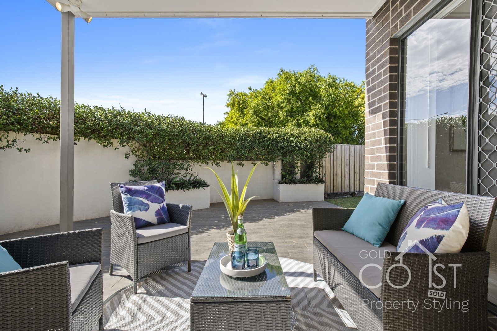 A patio with a couch , chairs , and a table.
