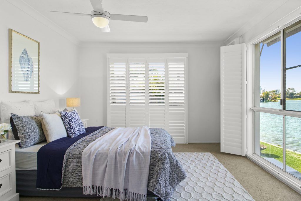 A bedroom with a large bed and a ceiling fan