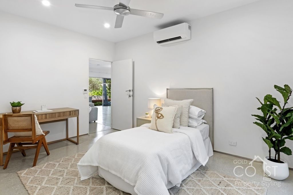 A bedroom with a bed , desk , chair and ceiling fan.