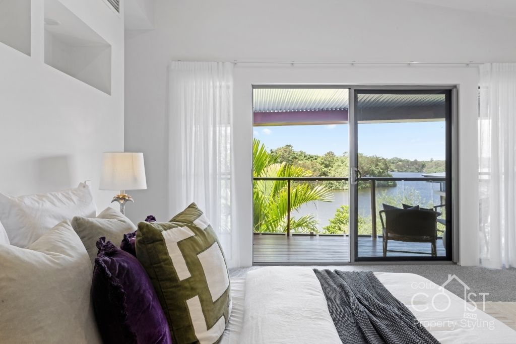 A bedroom with a large bed and a sliding glass door leading to a balcony.
