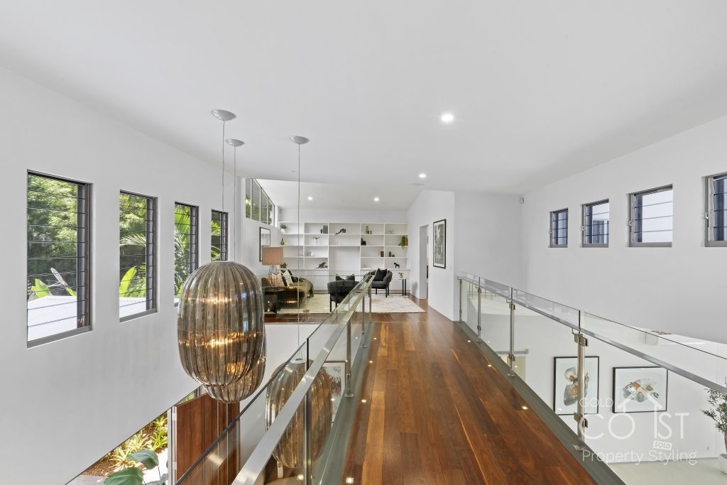 A hallway with a wooden floor and a glass railing