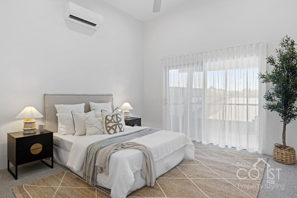 A bedroom with a bed , nightstand , and air conditioner.