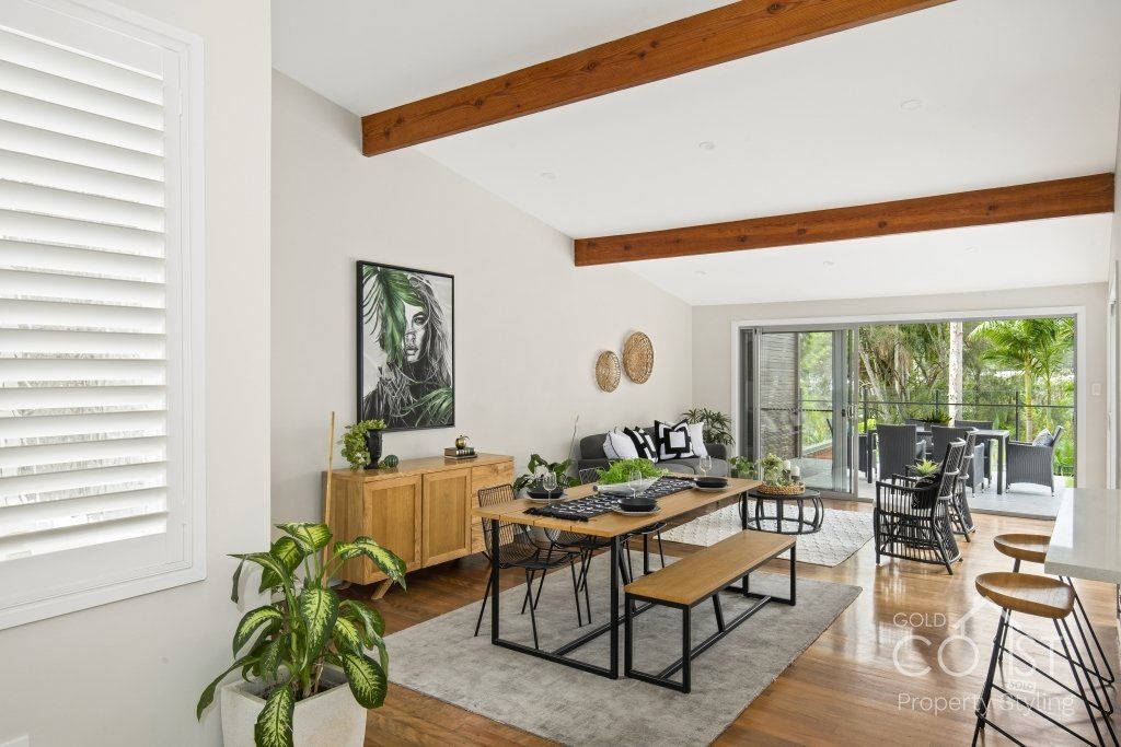 A living room with a couch , table , bench and stools.