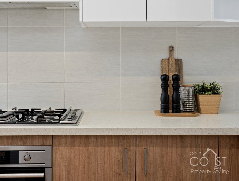 A kitchen with a stove top oven and wooden cabinets
