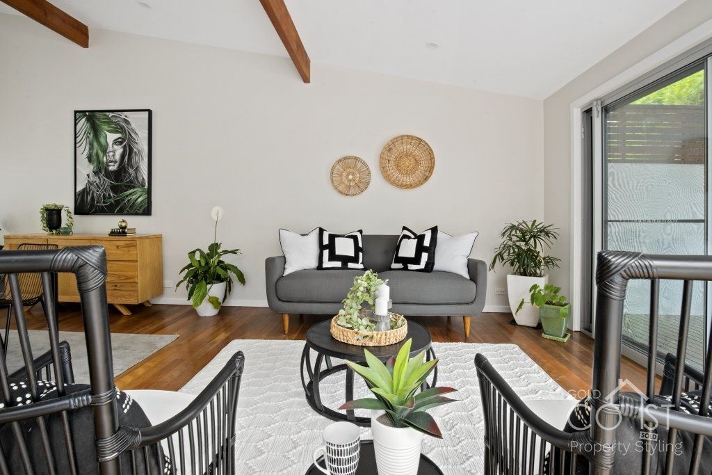 A living room with a couch , chairs , and a table.