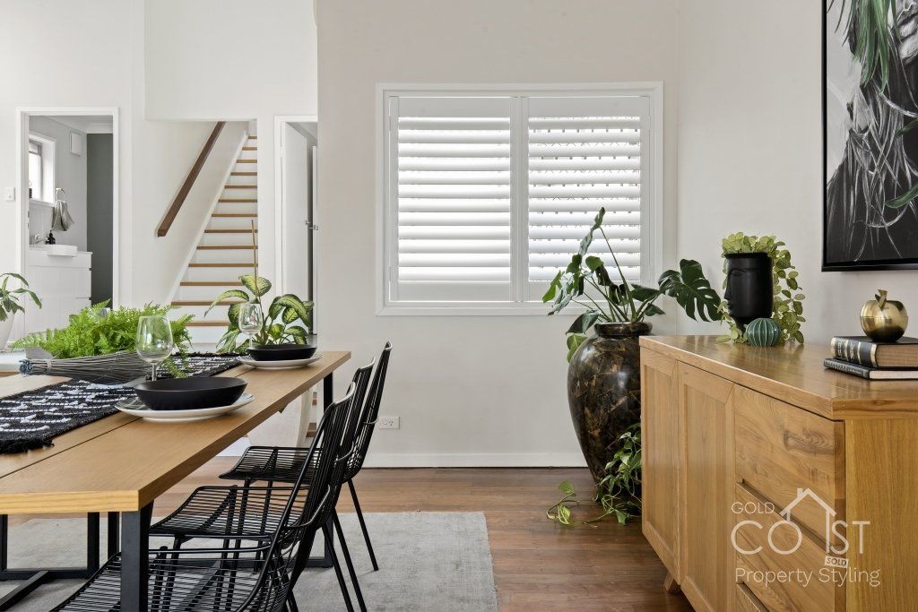 A dining room with a table and chairs and a window.