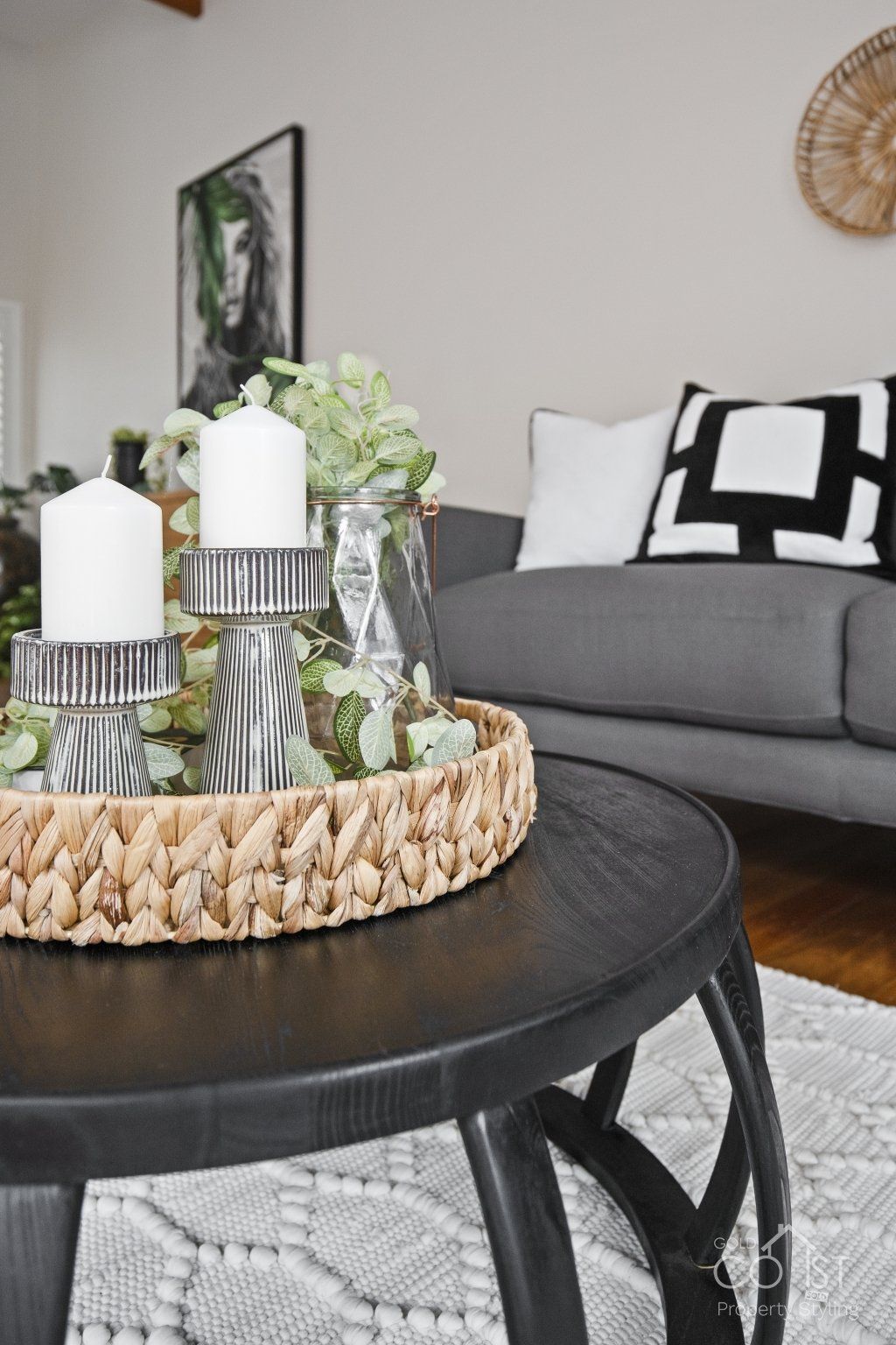 A living room with a couch and a coffee table with candles on it.
