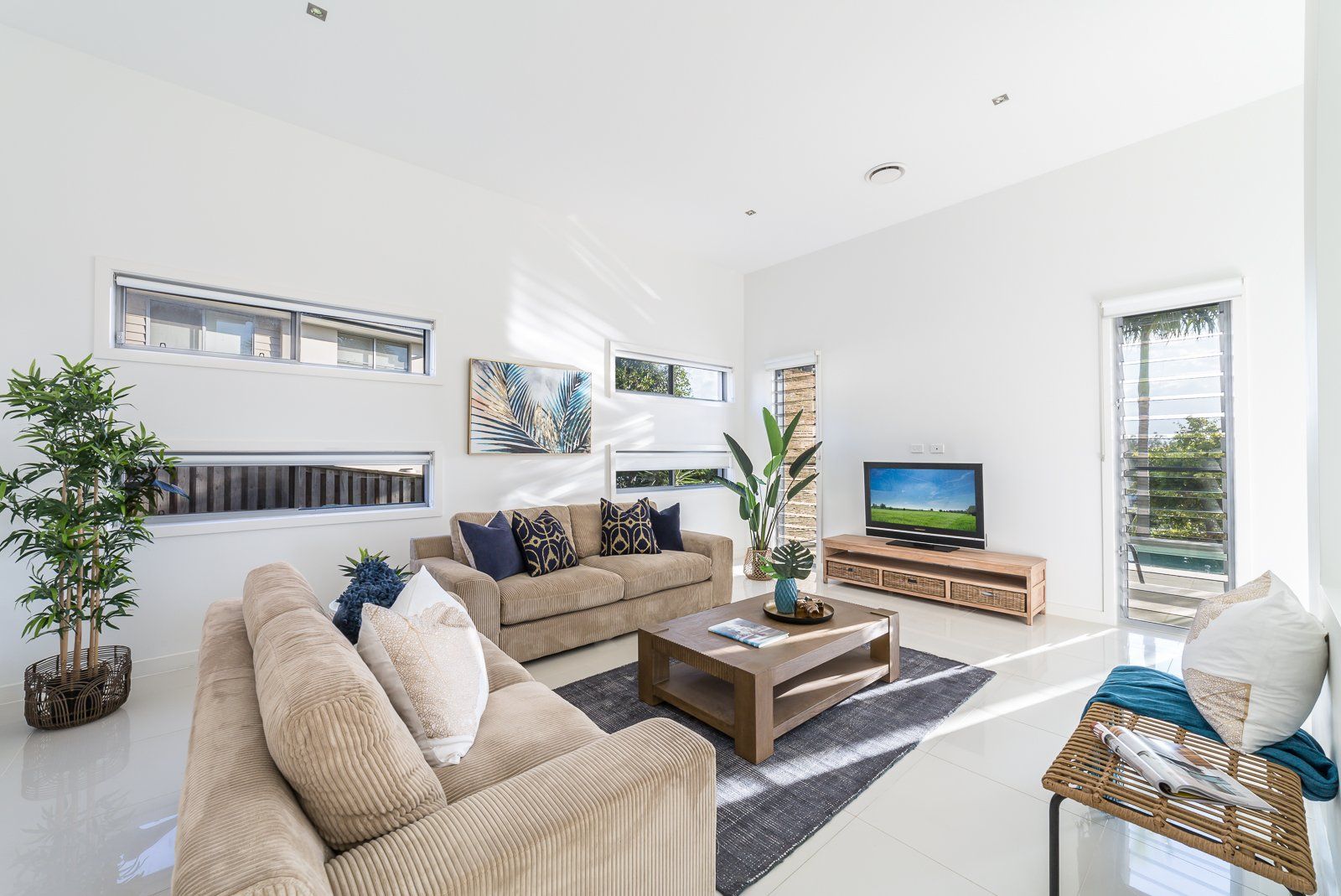 A living room with a couch , coffee table , and television.
