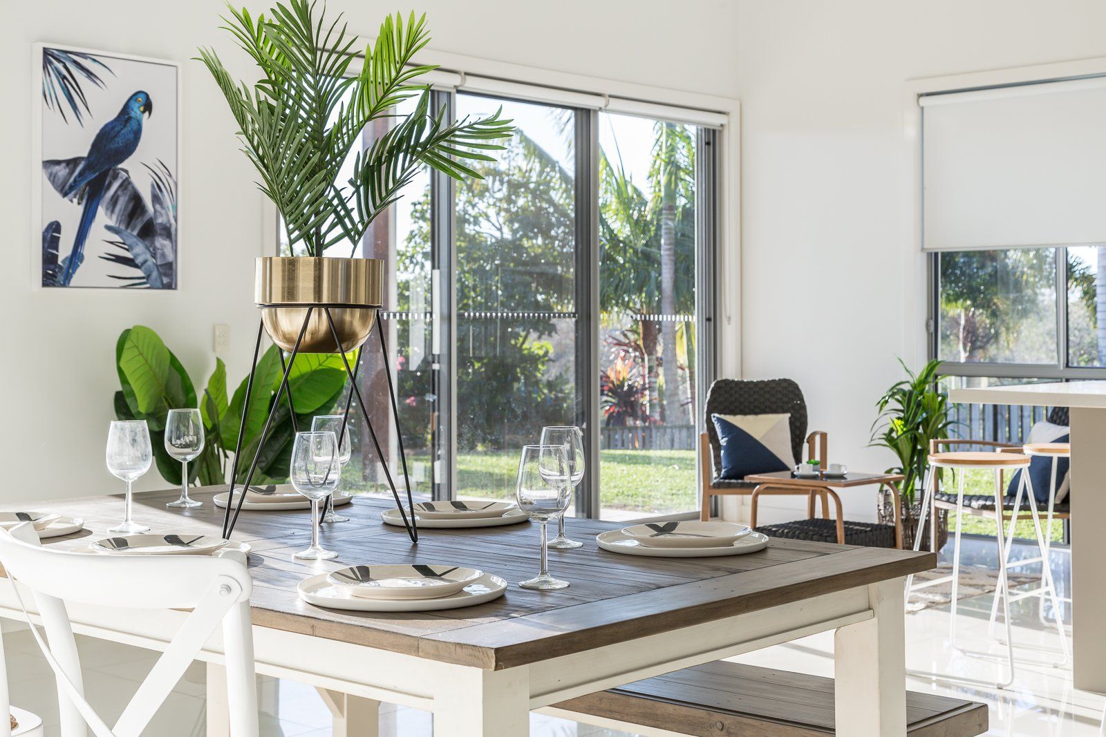A dining room with a table and chairs and a sliding glass door.