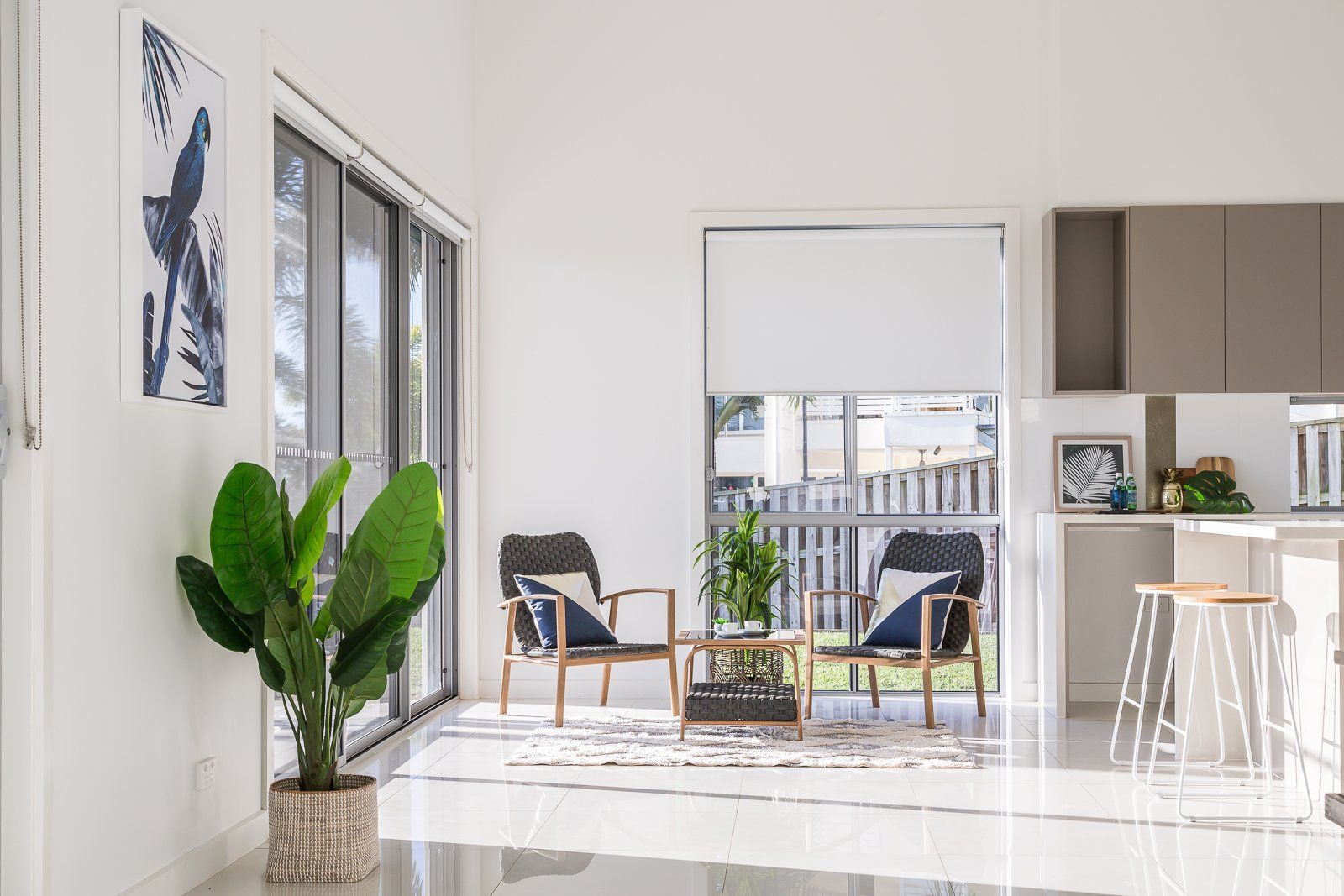 A living room with chairs , a table and a potted plant.
