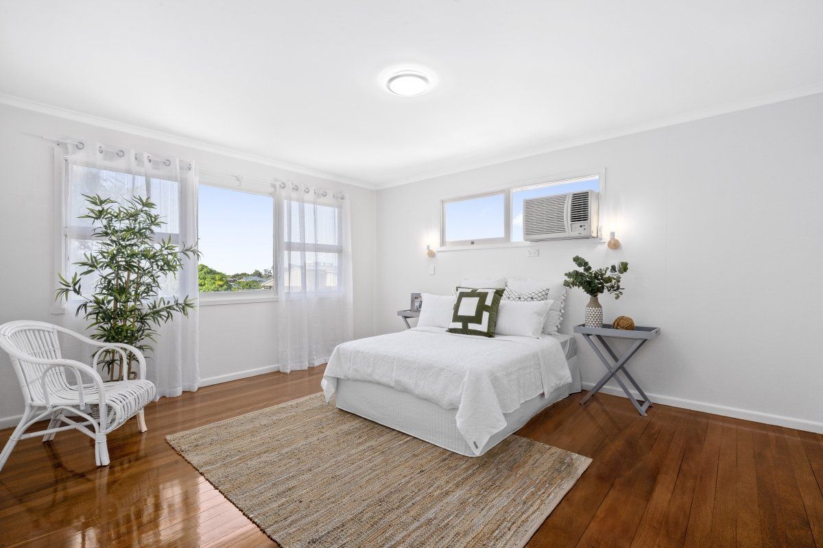A bedroom with a bed , chair , rug and window.