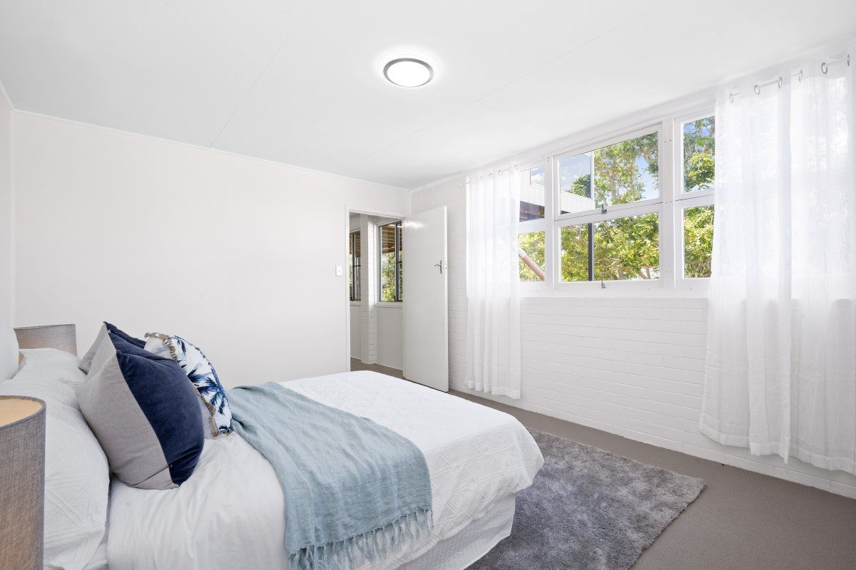 A bedroom with a bed , lamps , and a window.