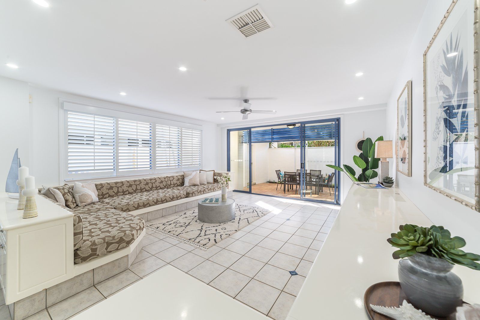 A living room with a couch , table , and sliding glass doors leading to a patio.
