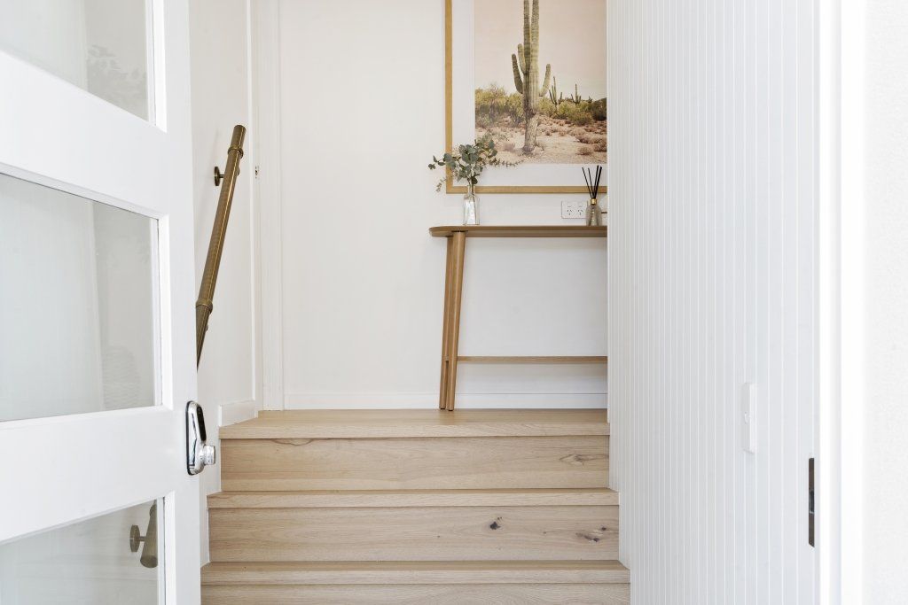 There is a picture of a cactus on the wall above the stairs.