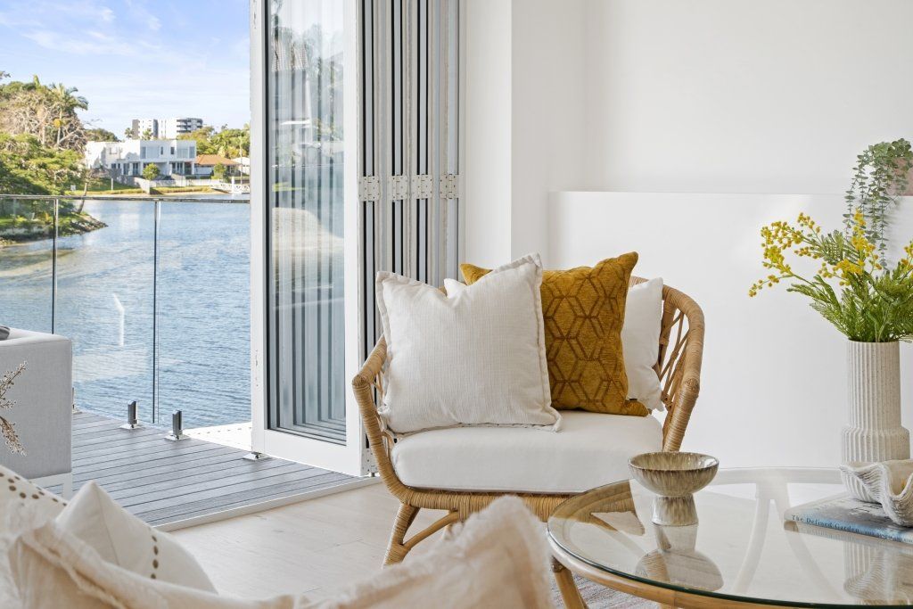 A living room with a couch , chair , coffee table and a view of the water.