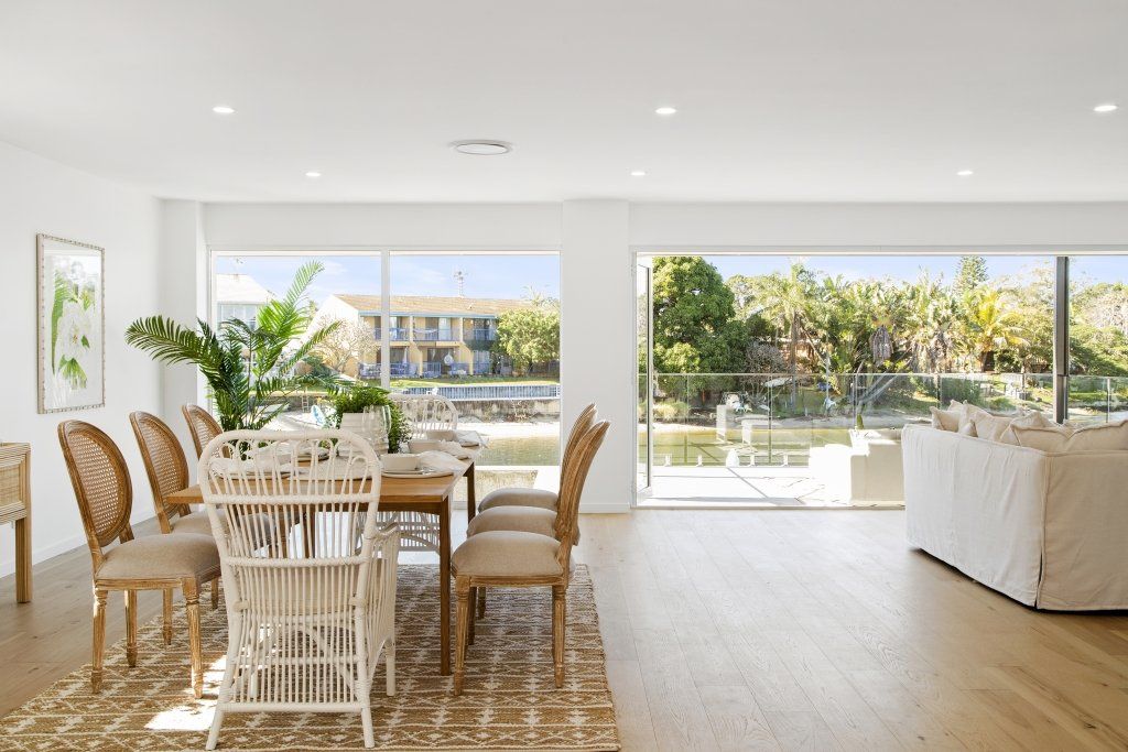 A living room with a dining table and chairs and a large window.