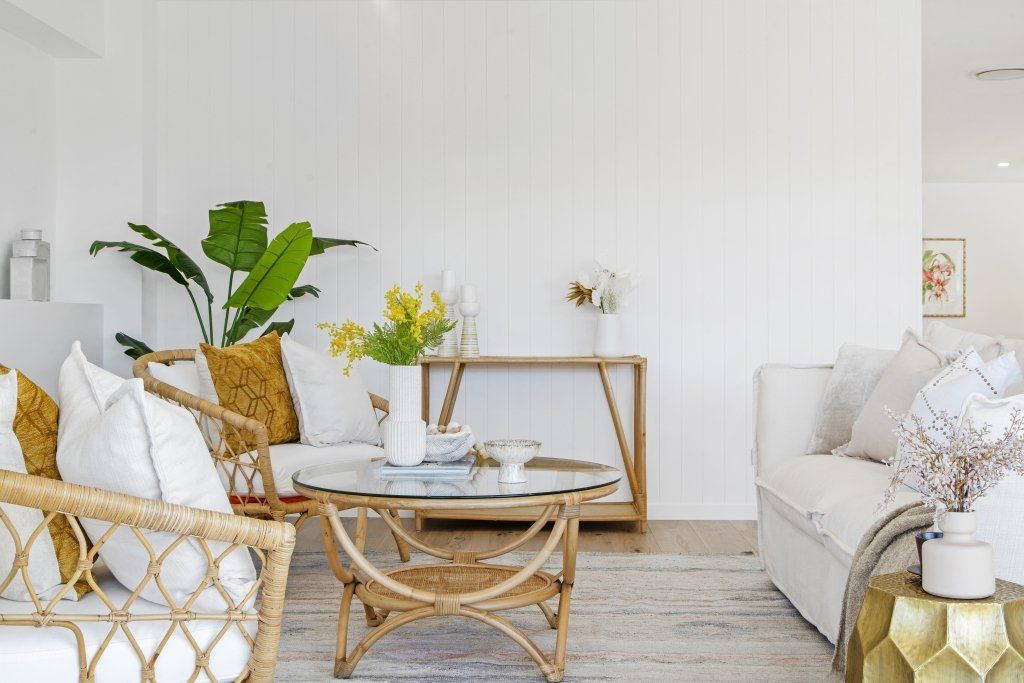 A living room with a couch , chair , coffee table and plant.