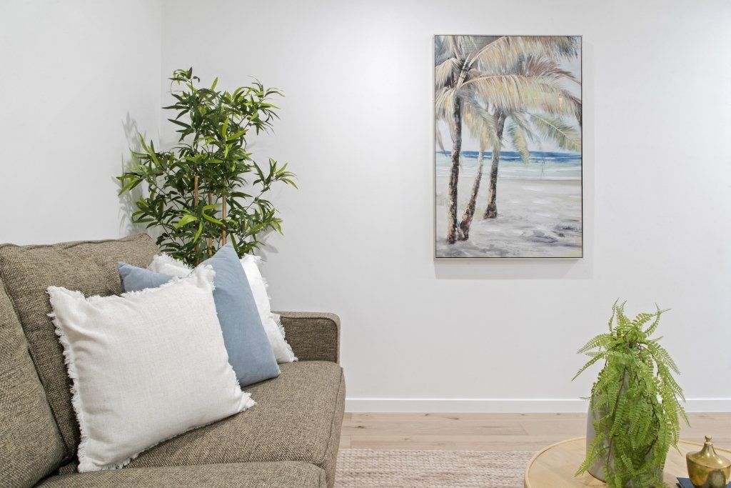 There is a painting on the wall above the couch in the living room.