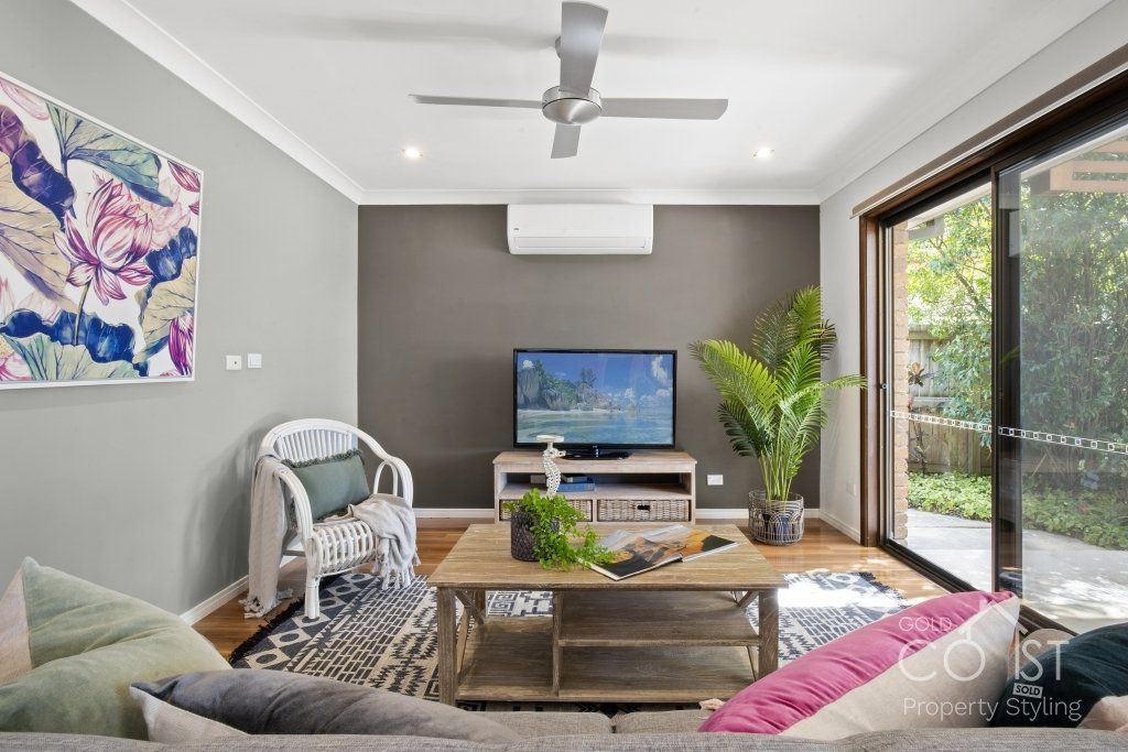 A living room with a ceiling fan and a flat screen tv