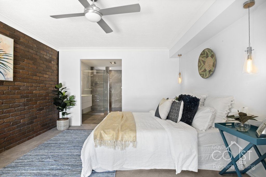 A bedroom with a large bed and a ceiling fan.