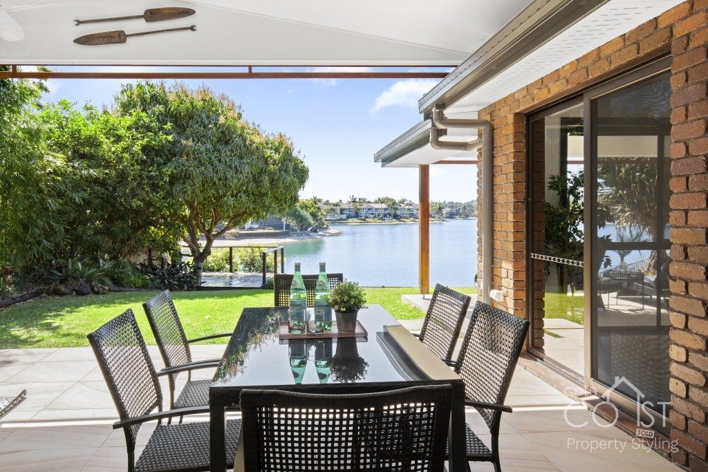 A patio with a table and chairs overlooking a body of water