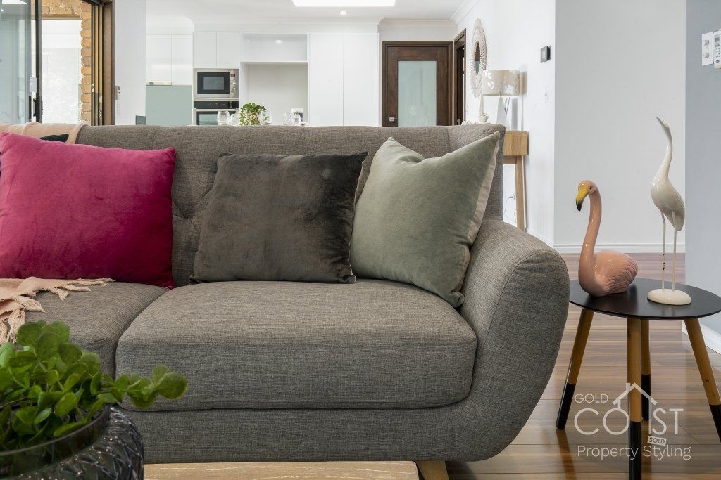 A living room with a couch , table , and flamingo statue.