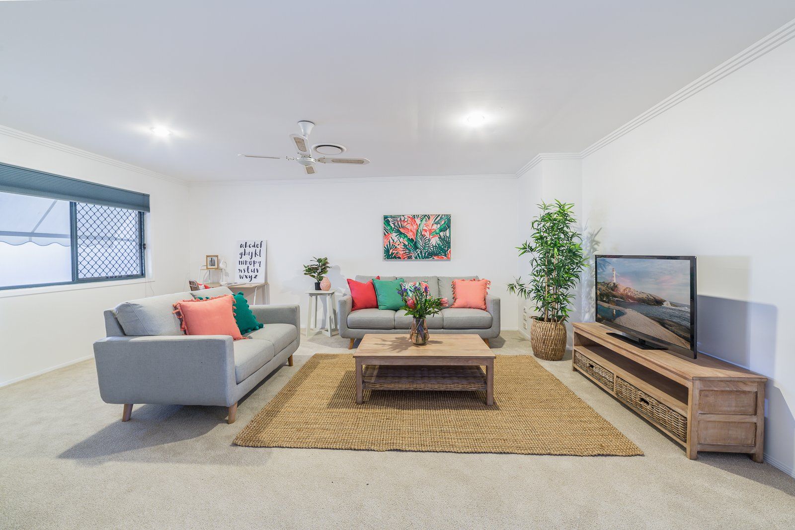 A living room with two couches , a coffee table , and a flat screen tv.
