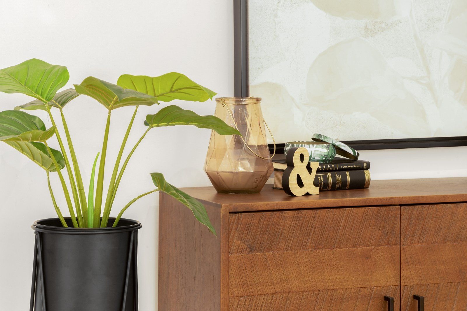 A potted plant is sitting on top of a wooden dresser.
