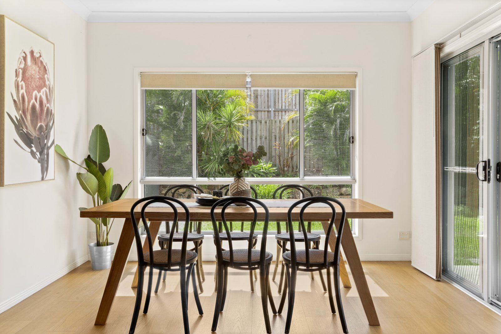A dining room with a table and chairs and a large window.
