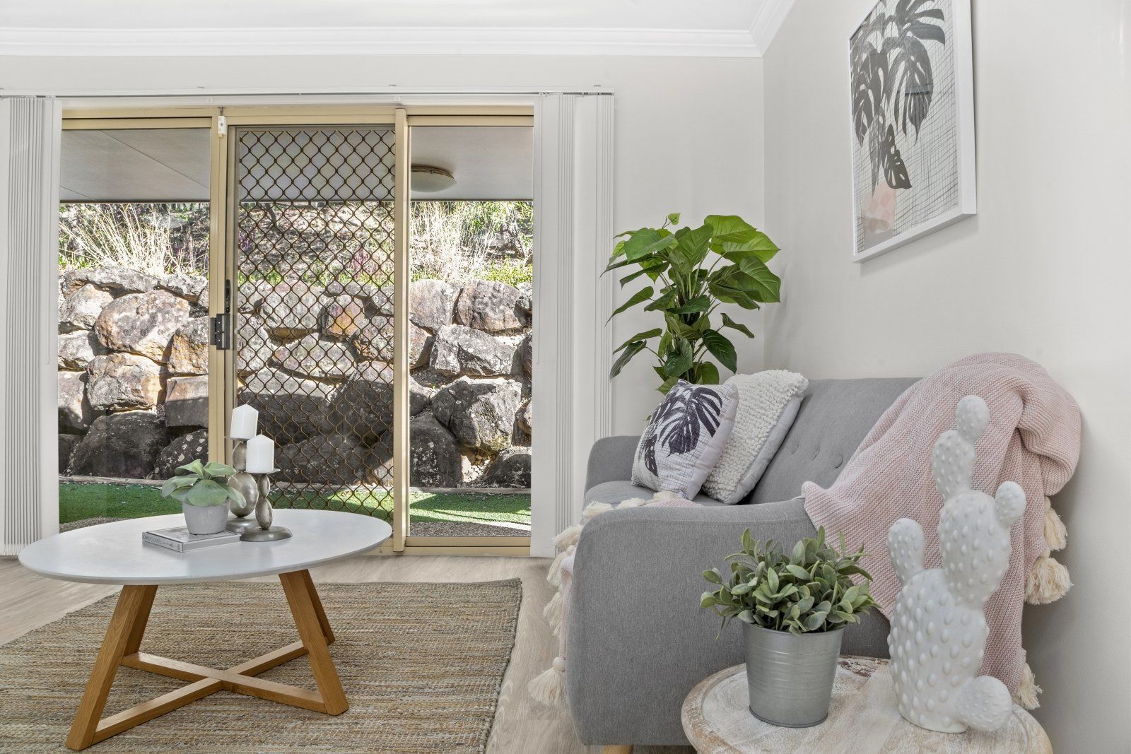 A living room with a couch , coffee table , and sliding glass doors.