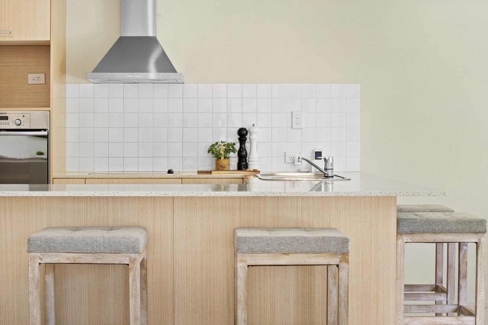 A kitchen with stools and a stove top oven