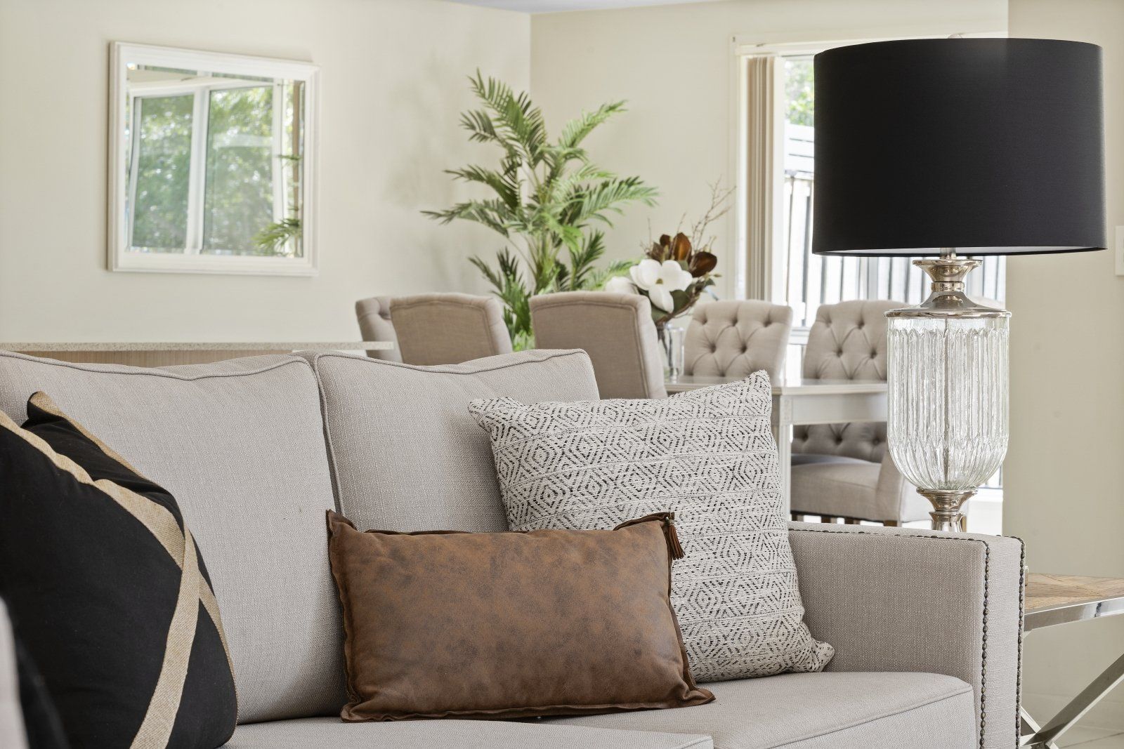 A living room with a couch and chairs and a lamp
