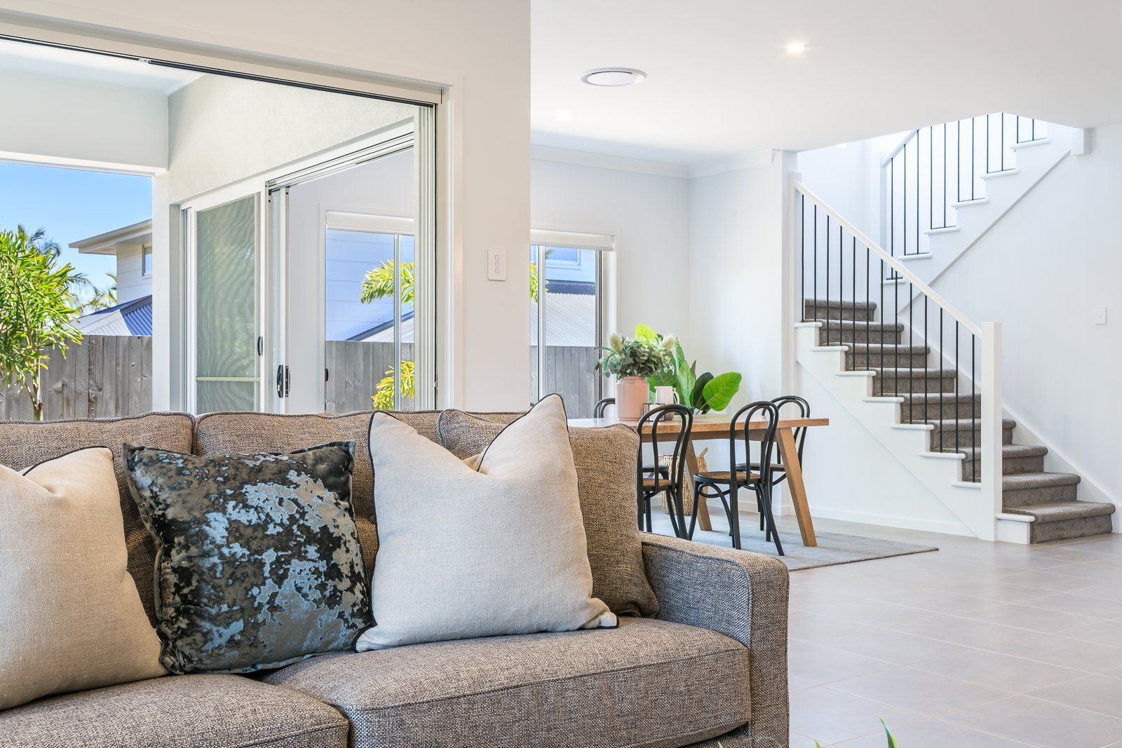 A living room with a couch and stairs in the background.