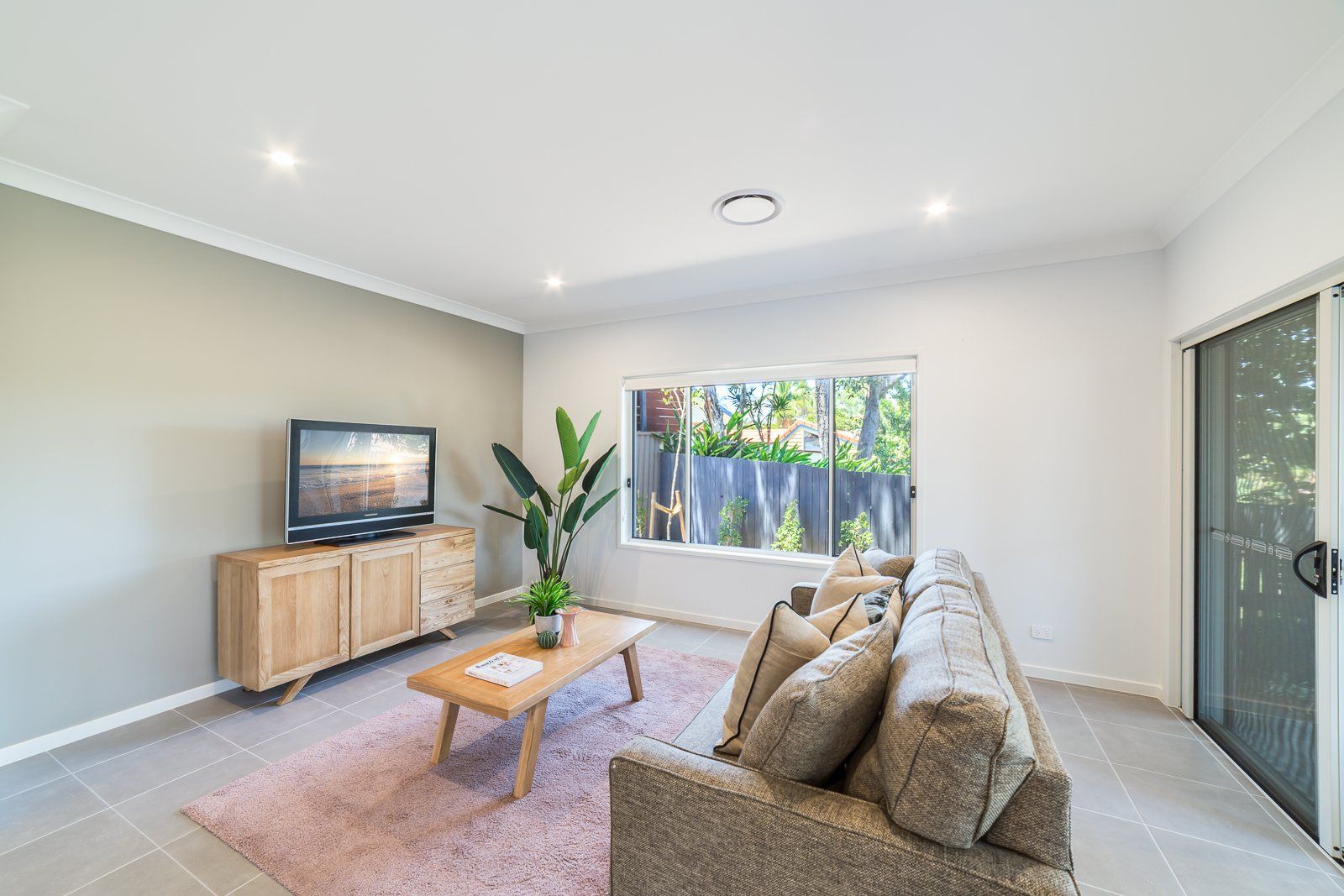 A living room with a couch , coffee table , and television.