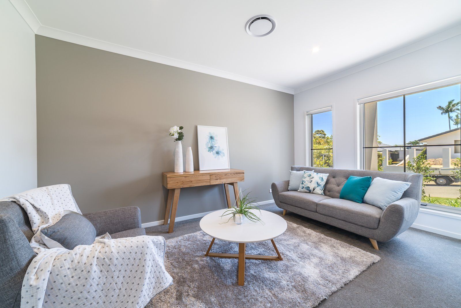 A living room with a couch , chair , table and rug.