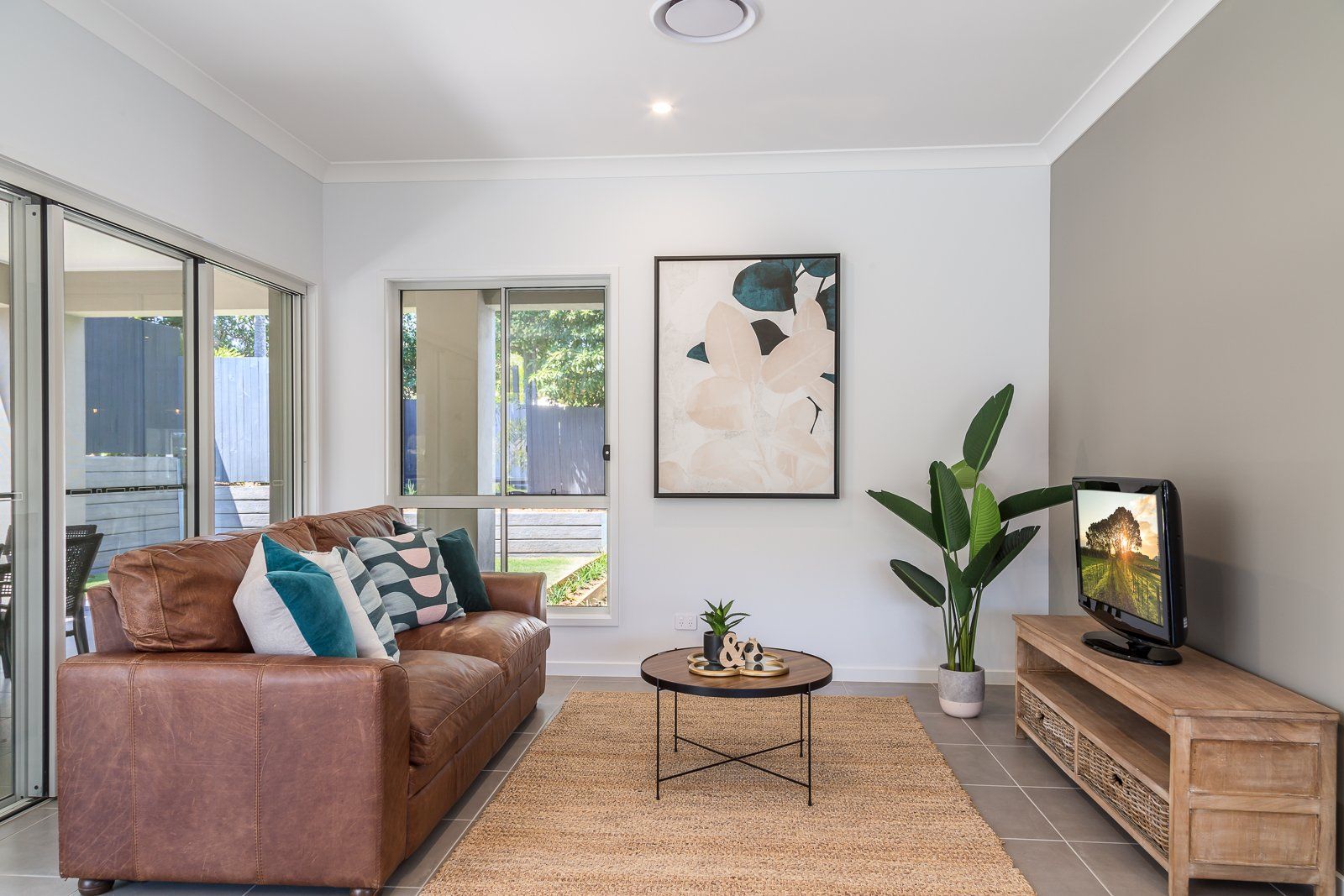 A living room with a brown couch and a flat screen tv