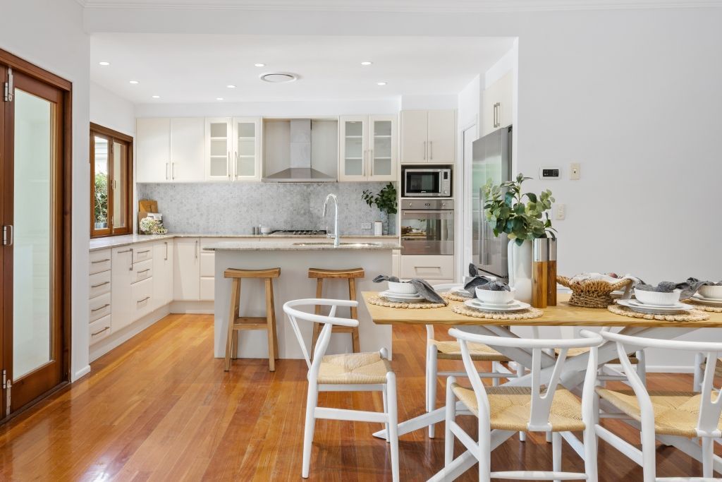 A kitchen and dining room in a house with a table and chairs.