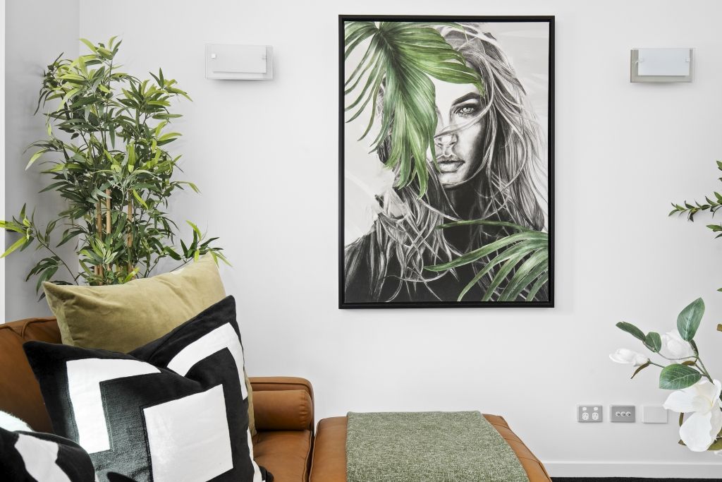 A living room with a couch and a painting on the wall.