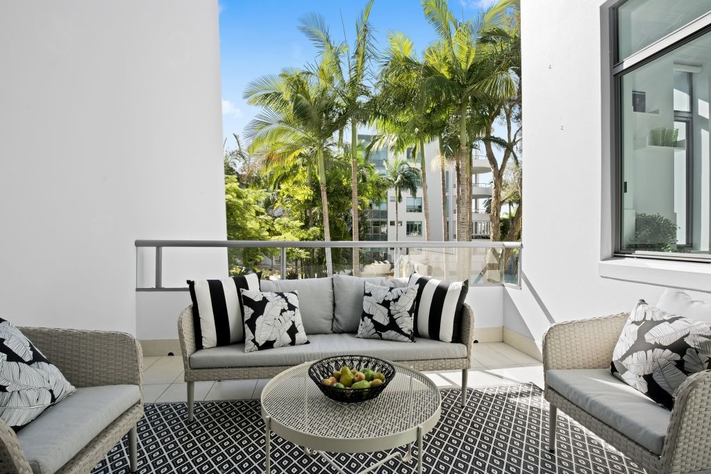 A balcony with a couch , chairs , and a table.