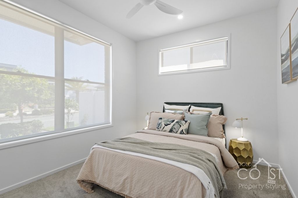 A bedroom with a large bed and a ceiling fan.