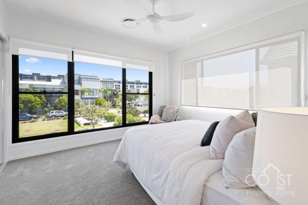 A bedroom with a large bed and a ceiling fan