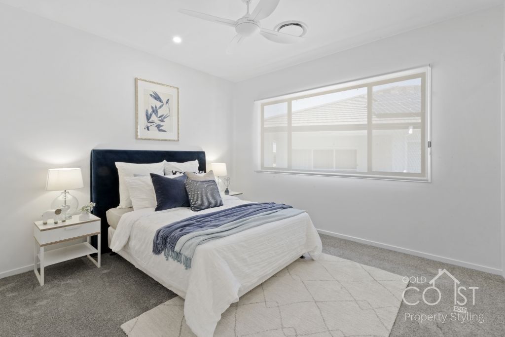 A bedroom with a large bed and a ceiling fan.