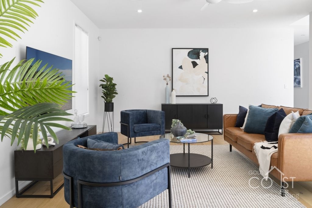 A living room with a couch , chairs , and a television.
